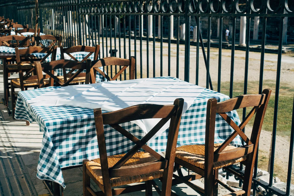 Green Gingham Tablecloth on Outdoor Wooden Chairs – Rustic Dining Setup